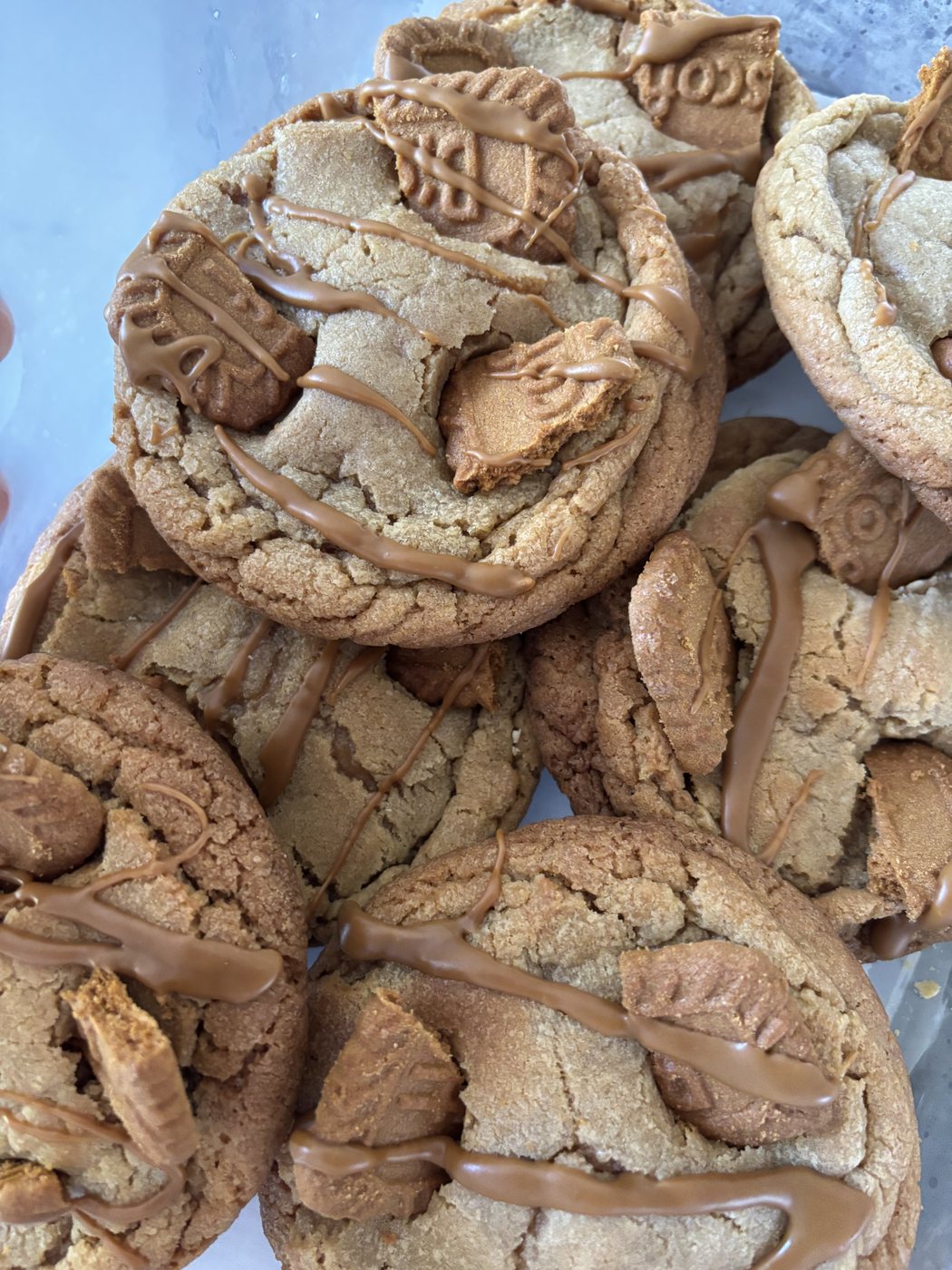 A pile of big cookies with a sweet drizzle on top