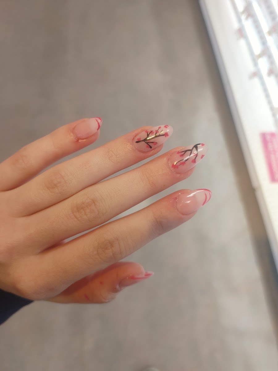 Almond shaped nails with hand painted cherry blossom branches on a sheer pink base at BeYOUtiful Nails