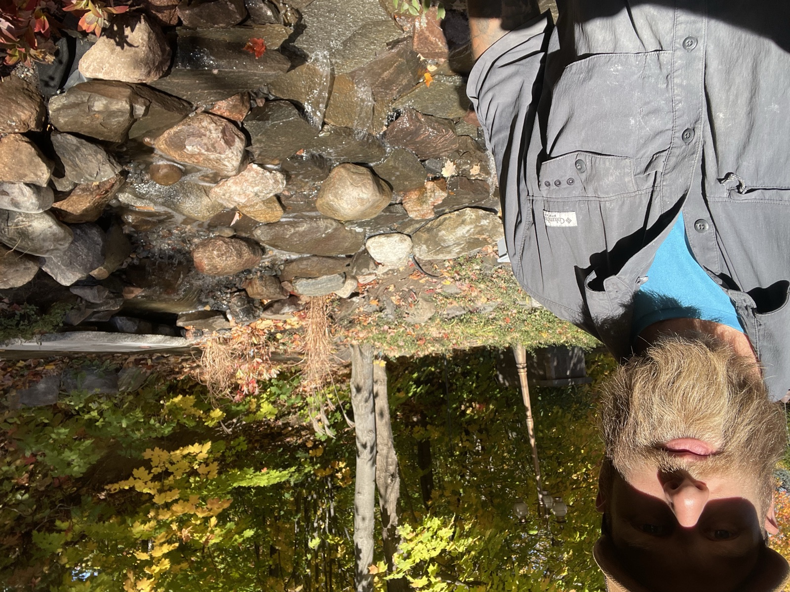 Dylan Bouwers of Bouwers Design Landscaping beside a pondless waterfall his crew built