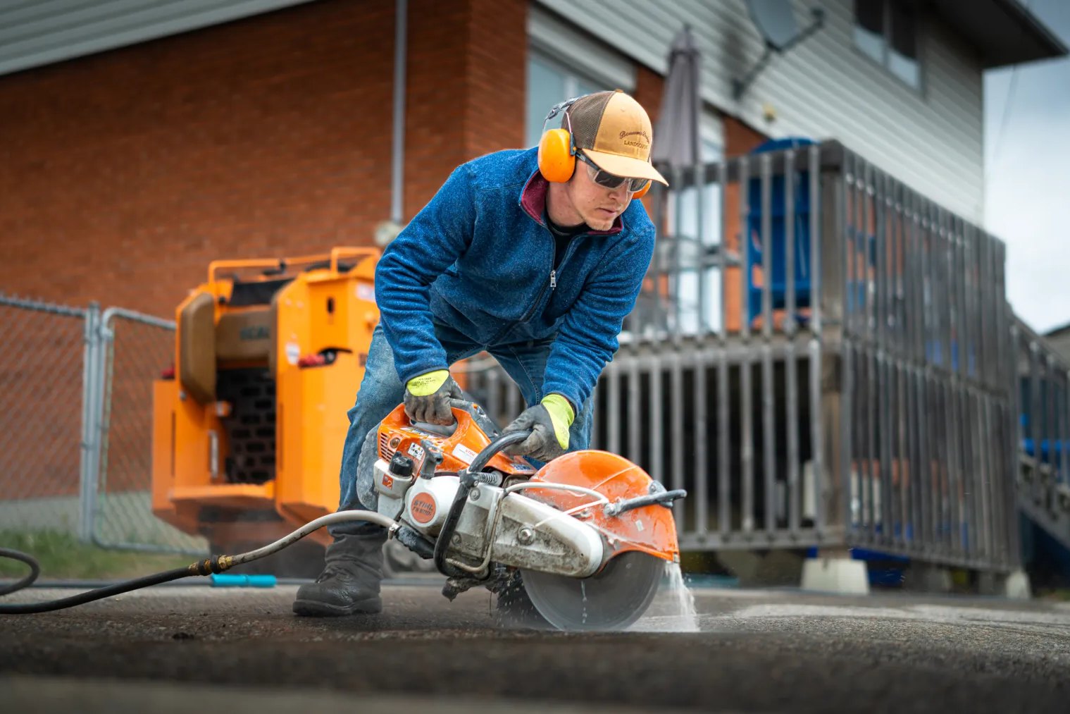 Bouwers Design Landscaping crew saw cutting interlock pavers on a North Bay job site