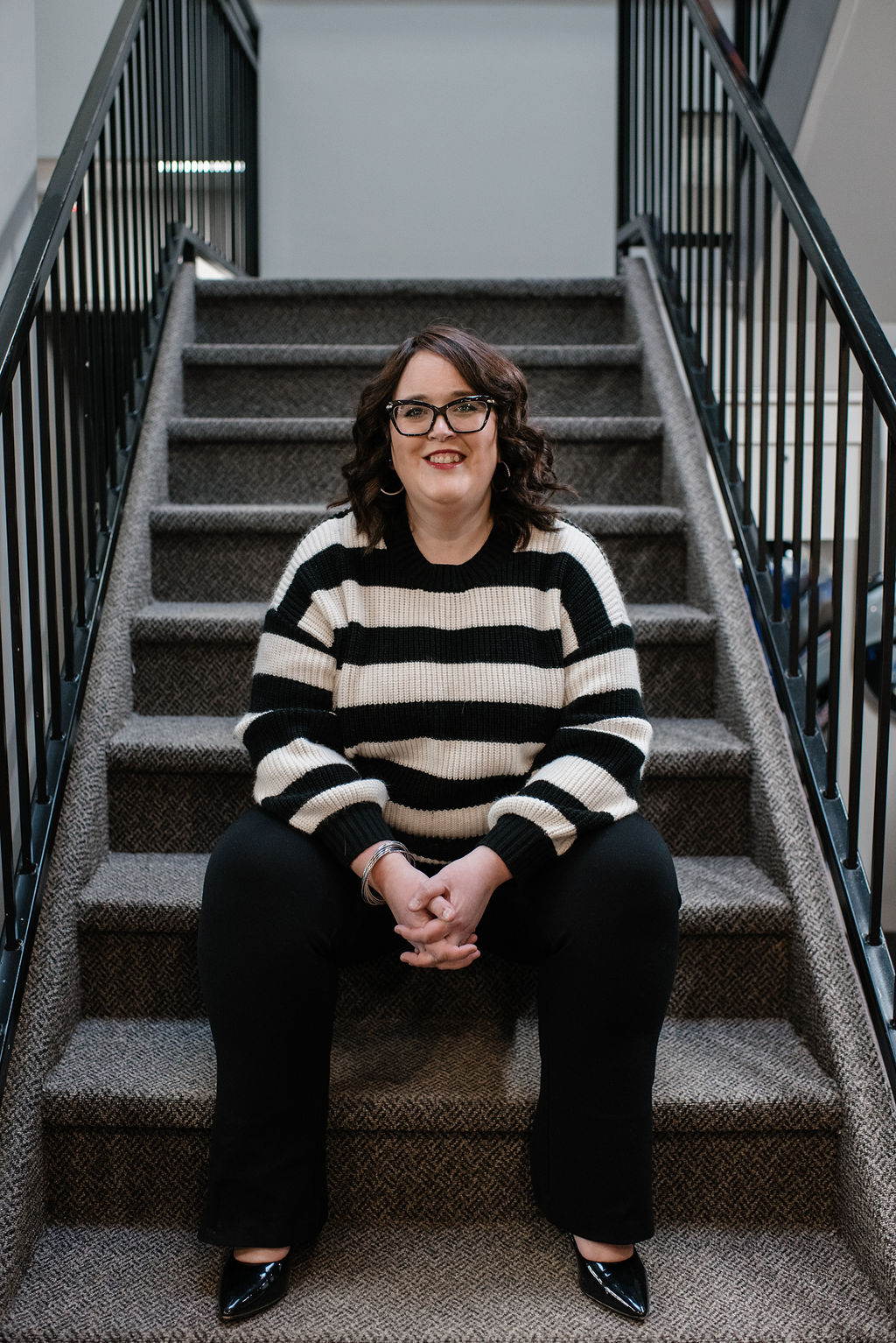 Brooke Bertrand seated on the stairs at her downtown North Bay office