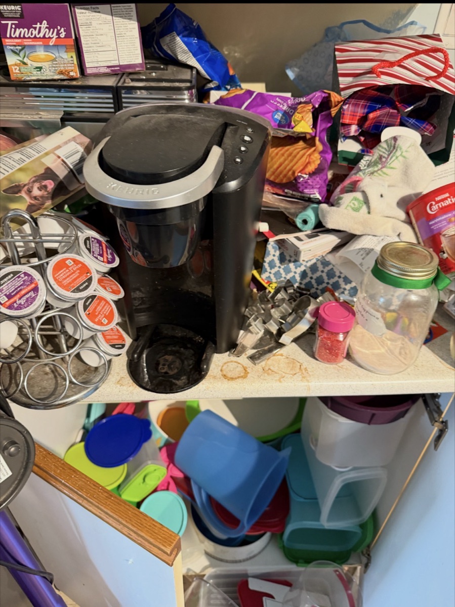 Cluttered kitchen counter with a coffee maker before a Busy Bee's Kleaning clean in North Bay