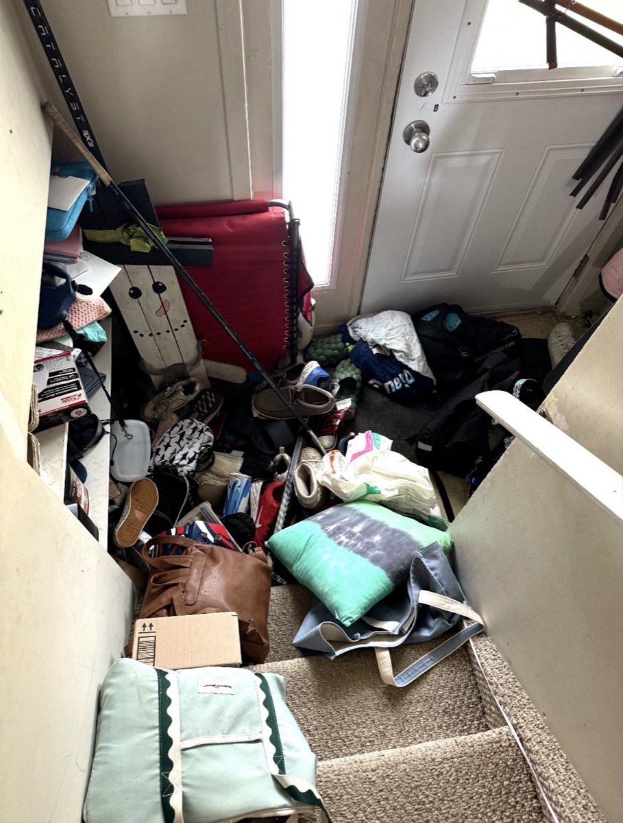 Front entry and stairs covered in shoes, bags and clutter before a Busy Bee's Kleaning clean