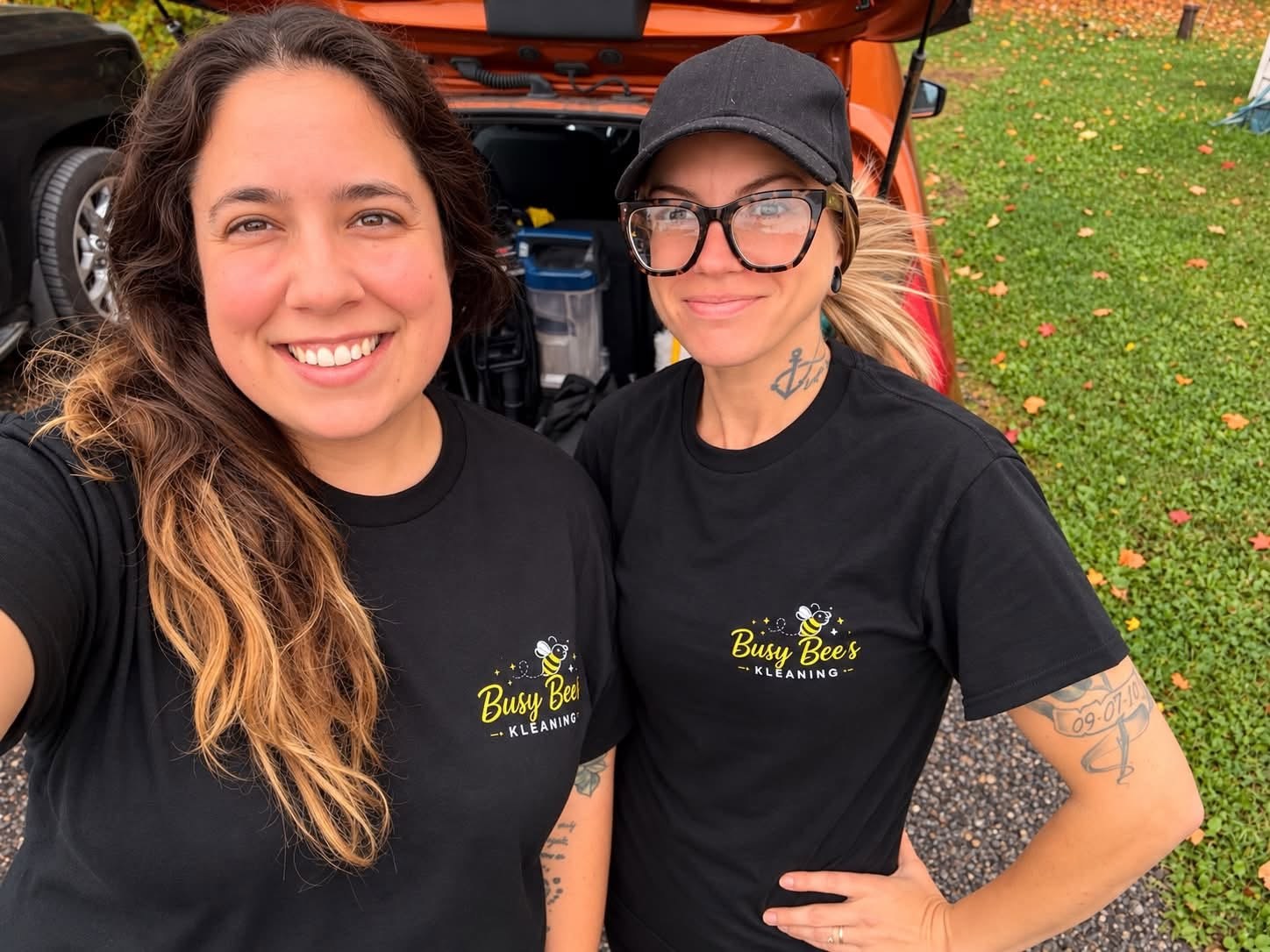 Krystal Wuerch and Kassandra in Busy Bee's Kleaning shirts in front of a car loaded with cleaning gear