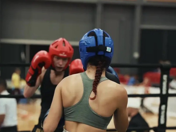A Coalition Martial Arts fighter in blue headgear competing in the ring