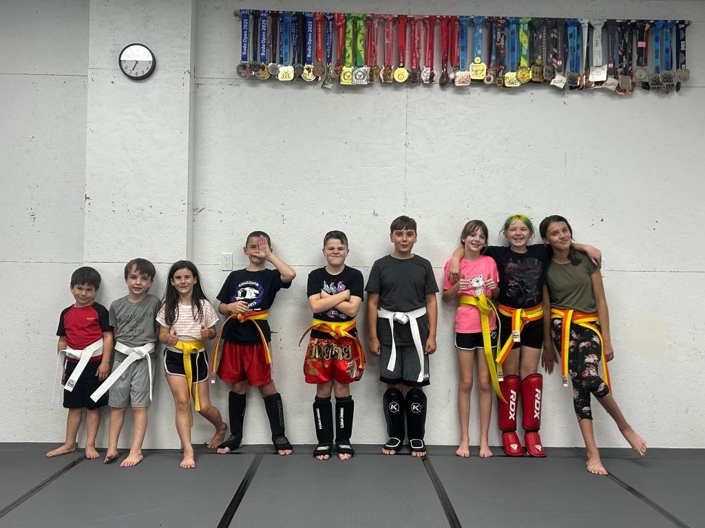 Kids kickboxing students lined up on the mats at Coalition Martial Arts
