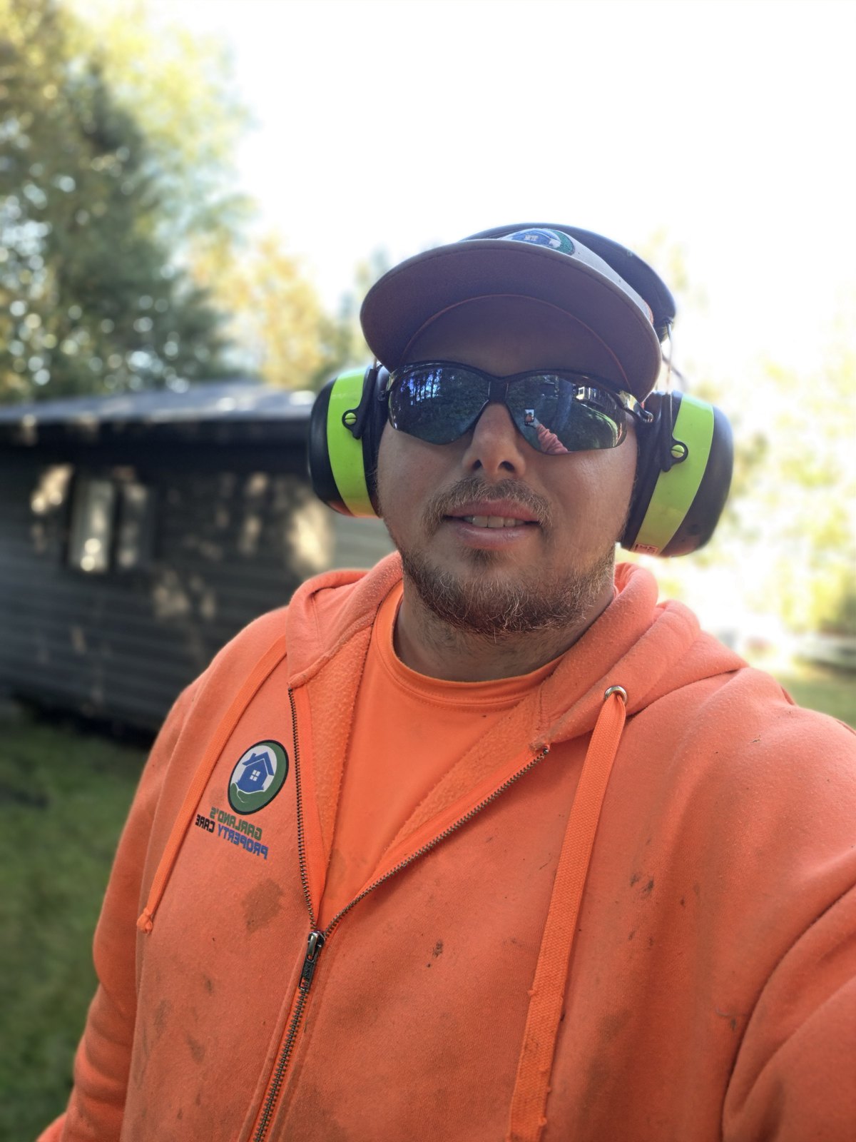 Lucas Garland on the job in a Garland's Property Care hoodie and ear protection