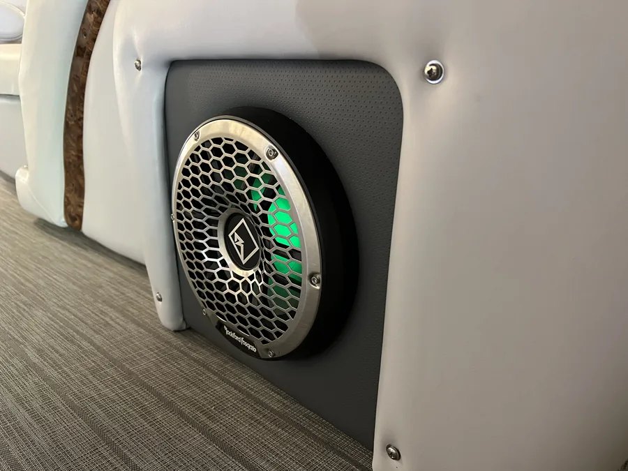 A marine speaker with green RGB lighting installed in a boat panel