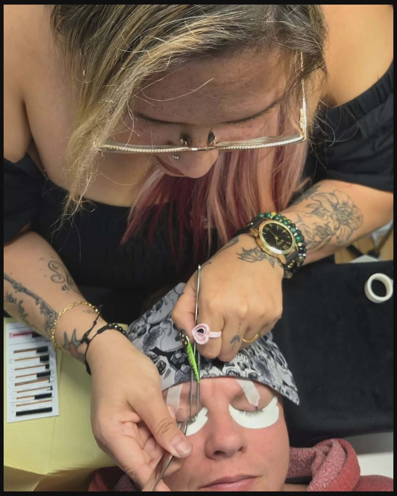 Kelly McKenzie applying lash extensions to a client with tweezers at Unique Esthetics