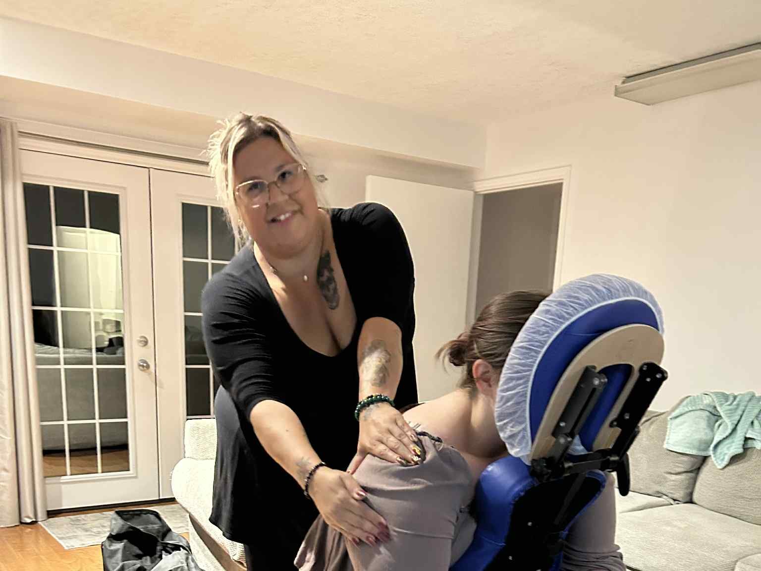 Kelly McKenzie giving a client a seated massage on her travelling massage chair during a mobile visit